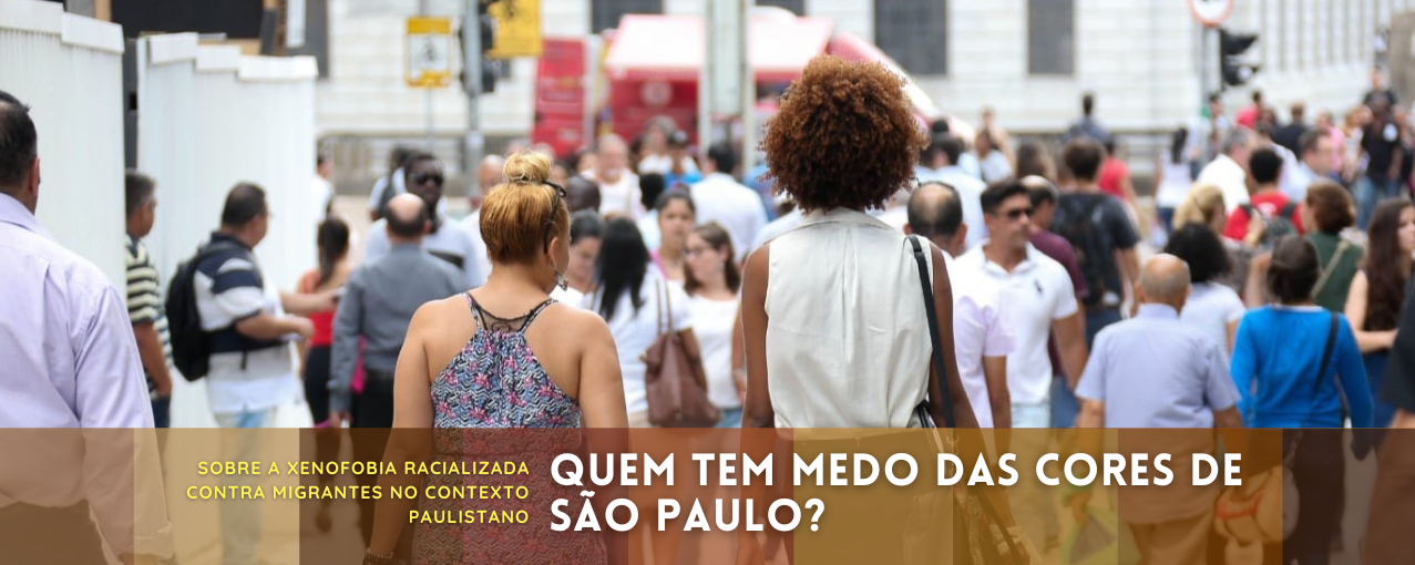 Uma mulher negra e uma mulher branca caminham lado a lado em rua movimentada, de costas para a câmera.